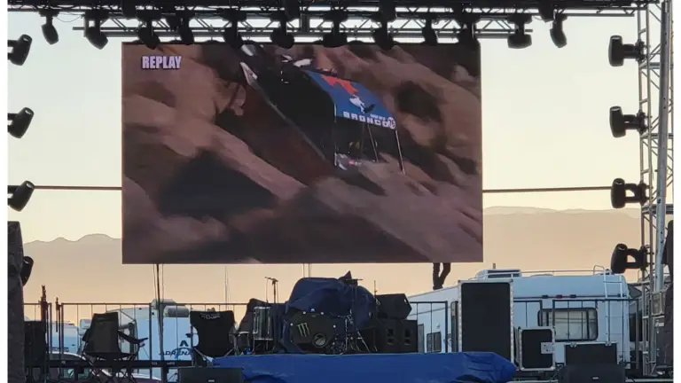 Outdoor modular LED wall displaying live replay content during a motorsports event.