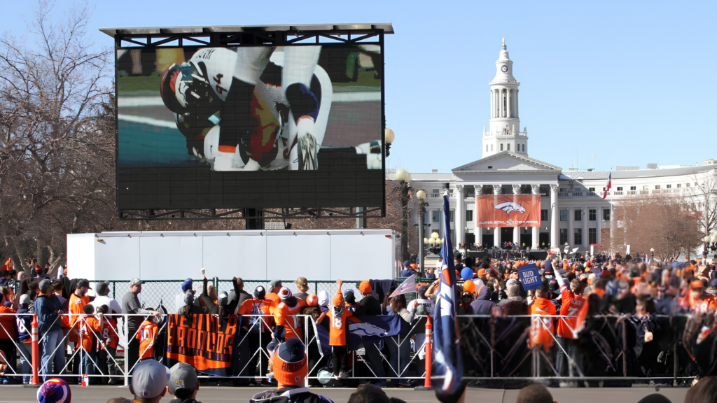 Mobile LED trailer displaying Denver Broncos game coverage at a tailgate event on the Colorado State Capitol grounds in Denver.