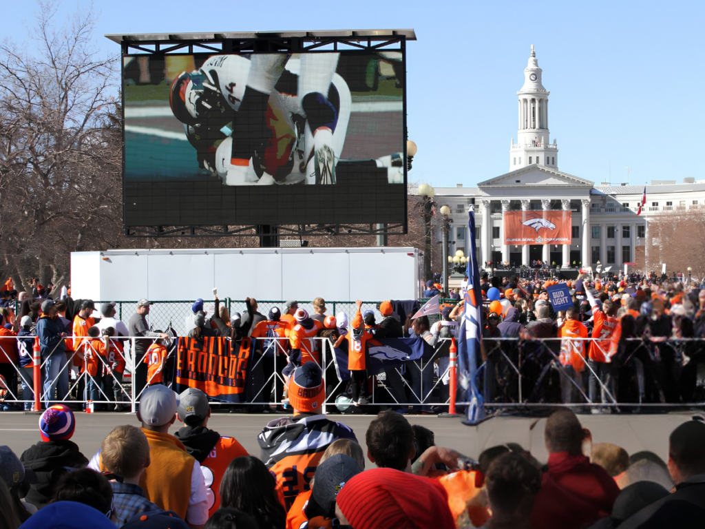 Mobile LED trailer displaying Denver Broncos game coverage at a tailgate event on the Colorado State Capitol grounds in Denver.